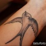 Фото простой татуировки ласточки на запястье, выполненной тонкими линиями. Минималистичный дизайн для любителей лаконичных татуировок.