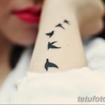 Фото нескольких маленьких татуировок ласточек, расположенных в ряд на запястье. Символичное изображение птиц, символизирующих свободу и стремление к мечте.
