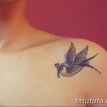 Фото тату ласточки с ключом на плече. Нежный и минималистичный рисунок татуировки в синих тонах.
