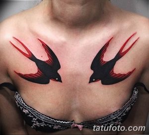 Фото тату двух ласточек на груди. Черно-красный рисунок татуировки с яркими акцентами и четкими линиями.