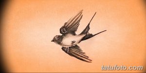 Фото тату маленькой ласточки на коже. Черно-белый минималистичный рисунок татуировки, выполненный в технике штриховки.