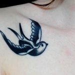 Фото тату маленькой ласточки на ключице девушки. Нежный и изящный рисунок татуировки в черно-белом цвете.