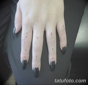 Фото минималистичных татуировок на пальцах: маленькие точки и короткие линии, выполненные черным цветом.