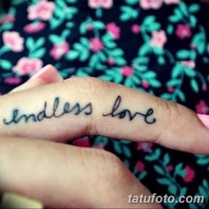 Фотография татуировки надписи 'endless love' черным цветом, выполненной на пальце руки. Изящный шрифт и небольшие размеры.