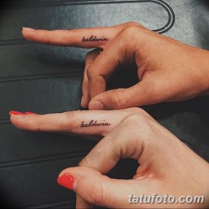 Фото парных татуировок на внутренней стороне кистей рук: надпись 'baldwin' на каждой руке. Минималистичный рисунок татуировки в черном цвете.