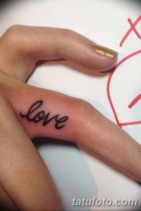 Фото тату надписи 'love' на пальце руки. Простой и элегантный рисунок татуировки черным цветом. Идеально для выражения чувств.