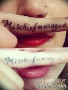 Фото тату: надпись "Mischief managed" на пальце руки, выполненная каллиграфическим шрифтом. Татуировка является отсылкой к популярной серии книг о Гарри Поттере.