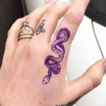 Фото тату: красочная татуировка змеи, обвивающей руку. Изображение выполнено в ярких фиолетовых и синих тонах, с детальной проработкой чешуи.