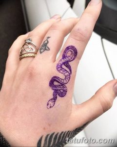 Фото тату: красочная татуировка змеи, обвивающей руку. Изображение выполнено в ярких фиолетовых и синих тонах, с детальной проработкой чешуи.