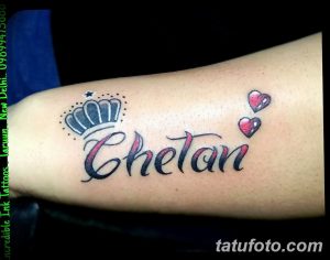Фото тату на предплечье: черная корона над именем 'Chetan', украшенная звездочкой и двумя сердцами. Яркий и индивидуальный рисунок татуировки.