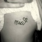 Фото маленькой татуировки с надписью 'Mia' и сердечком на коже. Минималистичный дизайн, нежный стиль, личное значение.