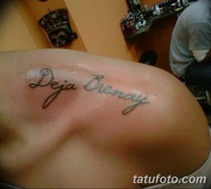 Фото татуировки на лопатке: надпись "Deja Bremay", выполненная красивым шрифтом.