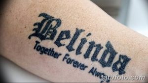 Фото татуировки с именем 'Belinda' и фразой 'Together Forever Always', выполненной в готическом стиле на предплечье.