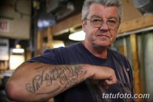 Фотография мужчины с татуировками на предплечье, выполненными в традиционном стиле.