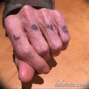 Фото тату: пожилой мужчина с небольшими татуировками в виде сердец на пальцах рук, демонстрирует свои татуировки.