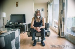 Фото пожилого мужчины с татуировками на руках и шее. Татуировки выполнены в традиционном стиле и изображают морские мотивы.