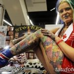 Фото тату: женщина, полностью покрытая яркими татуировками, позирует на тату-конвенции. Многообразие стилей и цветов.