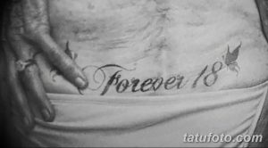 Фото тату: черно-белая надпись 'Forever 18' на груди мужчины, дополненная изображением летящей ласточки. Минималистичный стиль.