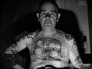 Фото старых татуировок на теле пожилого мужчины, демонстрирующее историю и самовыражение через искусство татуировки.