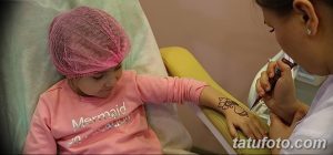 Фото тату хной на руке ребенка: простой и нежный узор, выполненный коричневой хной, украшает руку девочки, демонстрируя искусство мехенди.