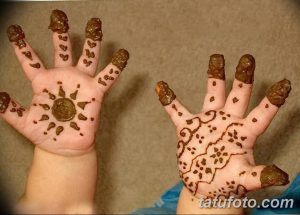 Фотография татуировок хной (мехенди) на ладошках двух детей. Простые узоры с изображением солнца и геометрических фигур.