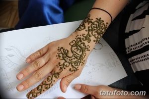 Фотография татуировки хной (мехенди) на руке женщины. Сложный узор с цветочными мотивами и тонкими линиями.