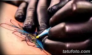 Фото процесса татуировки: мастер наносит краску на контур рисунка стрекозы. Детализированное фото тату.