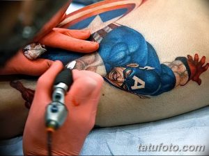Фото татуировки на спине: изображение Капитана Америки в полный рост, выполненное в ярких цветах и стиле комиксов.