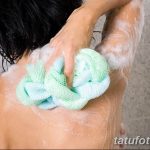 Фотография девушки, принимающей душ и использующей мочалку для тела. Идеально для иллюстрации гигиены и ухода за собой.