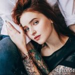 Фотография пары, где девушка с татуировками на руках нежно прижимается к парню. Идеально для иллюстрации любви и близости.