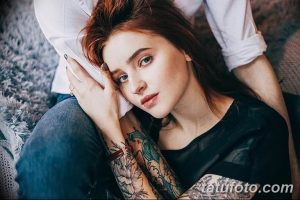 Фотография пары, где девушка с татуировками на руках нежно прижимается к парню. Идеально для иллюстрации любви и близости.