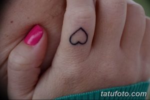 Фото татуировки в виде маленького черного сердца на пальце. Простой и лаконичный дизайн.