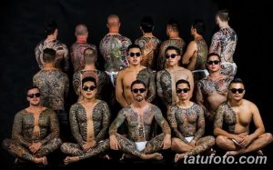 Фотография группы мужчин с масштабными татуировками в японском стиле Ирэзуми, покрывающими спины и другие части тела. Изображение демонстрирует сложность и детализацию японских татуировок.