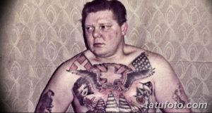 Фотография мужчины с татуировками на груди и руках в стиле олдскул. На татуировках изображены орлы, сердца и другие традиционные символы.
