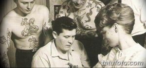 Черно-белое фото, изображающее процесс нанесения татуировки в начале 20 века. Тату-мастер работает над рисунком на теле клиента.