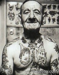 Фотография пожилого мужчины с множеством татуировок на лице, шее и теле. Изображение демонстрирует уникальный стиль и историю жизни человека.