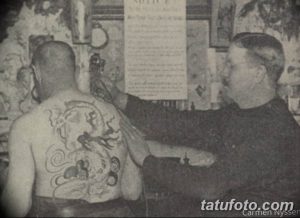 Фотография старинной татуировки дракона на спине мужчины, выполненной в традиционном стиле. Изображение демонстрирует историю татуировки и мастерство старых мастеров.