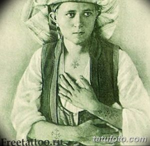 Фото тату: старинное фото мужчины с татуировками на груди и руках, изображающими кресты и другие религиозные символы. Черно-белое изображение, исторический стиль.