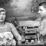 Старинная фотография, изображающая тату-мастера, делающего татуировку женщине в 1920-х годах. Видно тату-оборудование и уже нанесенные татуировки на руках женщины.