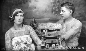 Старинная фотография, изображающая тату-мастера, делающего татуировку женщине в 1920-х годах. Видно тату-оборудование и уже нанесенные татуировки на руках женщины.