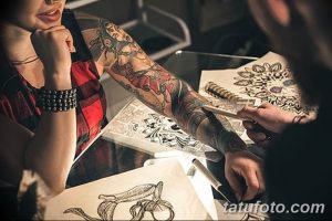 Фото: рука клиента с эскизом татуировки, рука мастера с карандашом, процесс создания рисунка.