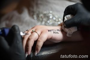 Фото тату: черная надпись с датой свадьбы 'April 28, 2018' и словом 'Mrs.' на женской руке, выполненная во время сеанса татуировки.