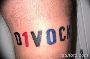 Фото тату надписи 'DIVOCK' на предплечье, выполненной в ярких цветах: красном, синем, сером и черном.