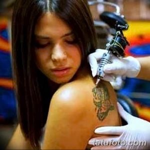 Фотография процесса нанесения татуировки на спину девушки, мастер работает тату-машинкой.