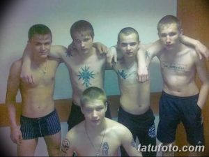 Фотография группы парней с татуировками на теле, позирующих вместе.