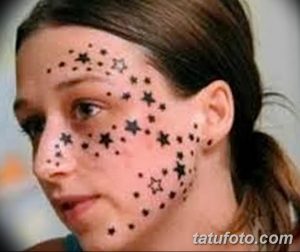 Фотография девушки с татуировкой в виде звезд на лице и шее.