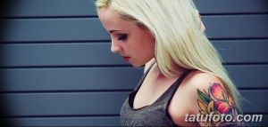 Фото тату: Цветная татуировка на плече девушки с изображением сочных персиков и зеленых листьев.