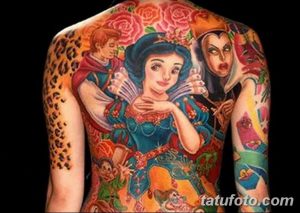 Фото красочной татуировки на спине, изображающей персонажей сказки о Белоснежке: принцессу, гнома, злую королеву и розы. Яркий рисунок татуировки в мультяшном стиле.