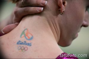 Фото тату олимпийских колец и надписи 'Rio 2016' на плече, символизирующее участие в Олимпийских играх в Рио-де-Жанейро.