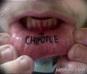 Фото тату: Необычная и вызывающая татуировка с надписью 'CHIPOTLE' на внутренней стороне нижней губы. Рисунок татуировки выполнен черными чернилами.